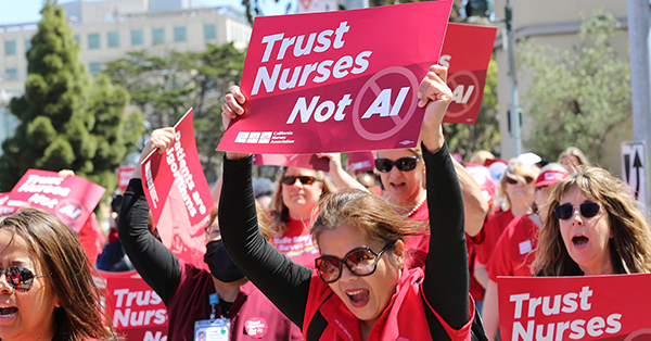 Nurses at rally, holding signd that say "Trust nurses, not AI"